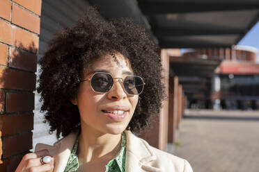 Afro junge Frau mit Sonnenbrille an einem sonnigen Tag - JCCMF01208