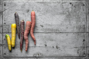 Carrots lying on gray wooden surface - ASF06718