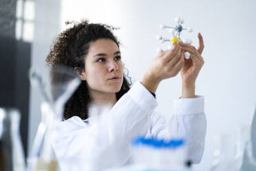Female researcher analyzing molecular structure at chemistry lab - GIOF11243