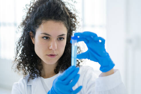 Female researcher examining chemical solution clinic - GIOF11249