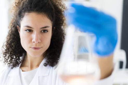 Young female researcher examining solution at clinic - GIOF11282