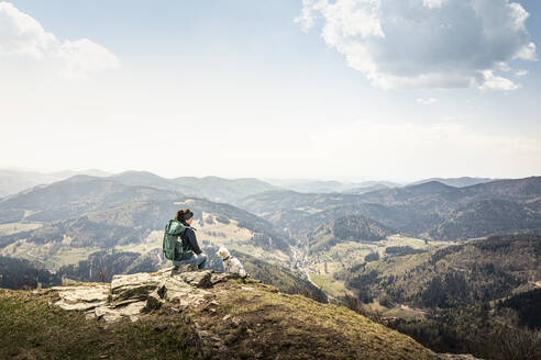 Wanderin mit Blick auf die Aussicht, während sie auf dem Kandel in Baden-Württemberg, Deutschland, sitzt - MSUF00526