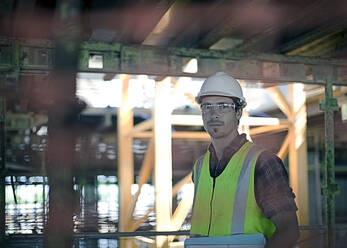 Confident male construction worker at construction site - AJOF01066