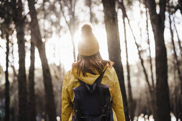 Woman with backpack exploring in forest - EBBF02477