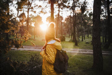 Female tourist with backpack standing in forest - EBBF02482