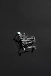 Shopping cart against black background - MAUF03722