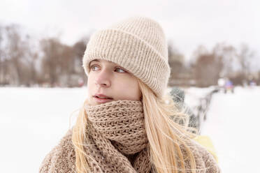 Beautiful girl wearing knit hat looking away during winter - VYF00418