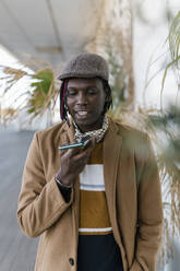 African man talking on smart phone through speaker - EGAF01821