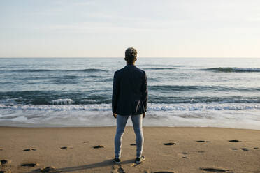 Man looking at view while standing at beach - JRFF05042