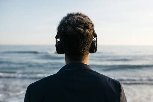 Afro man with headphones at beach - JRFF05043