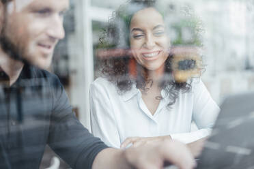 Businesswoman smiling while working with colleague at cafe - JOSEF03440