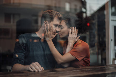 Couple doing romance while sitting at cafe stock photo