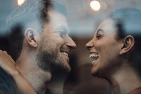 Nahaufnahme eines lächelnden Paares, das sich im Café ansieht - JOSEF03515