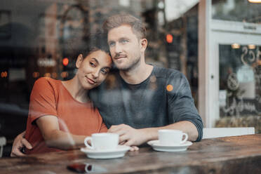 Paar schaut weg, während es zusammen im Café sitzt - JOSEF03571