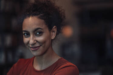 Smiling woman staring whiles sitting at cafe - JOSEF03580