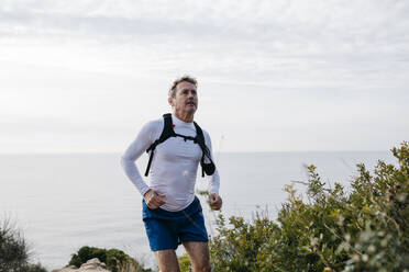 Man looking up while standing against cloudy sky - JRFF05072