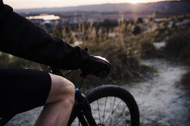 Sportsman riding bicycle during sunset - EBBF02518