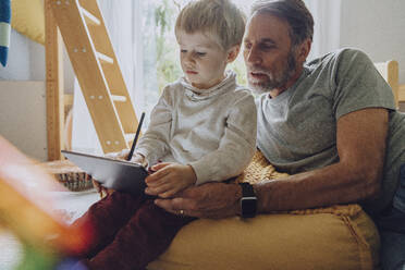 Vater sucht Sohn, der einen digitalen Tablet-Computer im Schlafzimmer benutzt - MFF07166