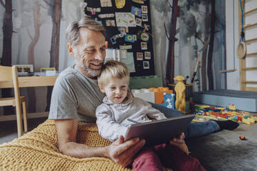 Lächelnder Vater mit süßem Sohn E-Learning auf digitalem Tablet - MFF07168