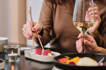 Junge Frauen essen Sushi und trinken Wein im Restaurant - AODF00287