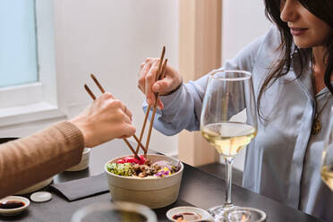 Weibliche Kundin isst im Restaurant mit Stäbchen - AODF00305