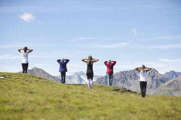 Kaukasischer Mann und Frauen üben Yoga vor einem Berg - CVF01662