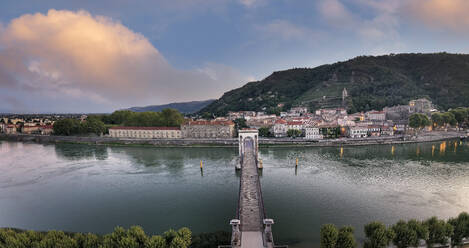 Frankreich, Ardeche, Tournon-sur-Rhone, Panorama der Brücke Passerelle Marc Seguin und der Stadt am Fluss in der Abenddämmerung - HAMF00839