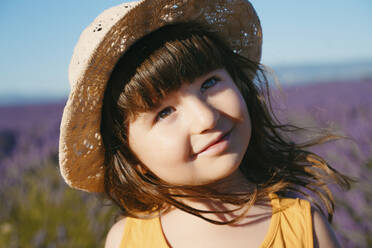 Porträt eines süßen kleinen Mädchens mit Strohhut, das im Freien steht - GEMF04695