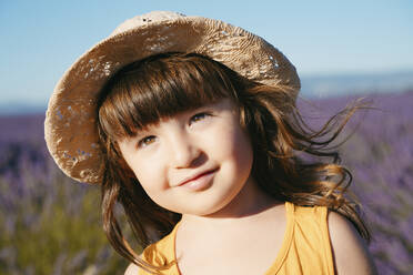 Porträt eines süßen kleinen Mädchens mit Strohhut, das im Freien steht - GEMF04696