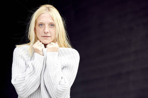 Blond young woman in sweater at parking garage stock photo