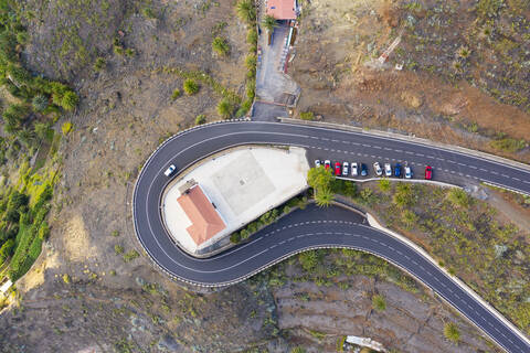 Spanien, Valle Gran Rey, Drohnenansicht der Straße, die sich um die Kirche San Antonio windet, lizenzfreies Stockfoto