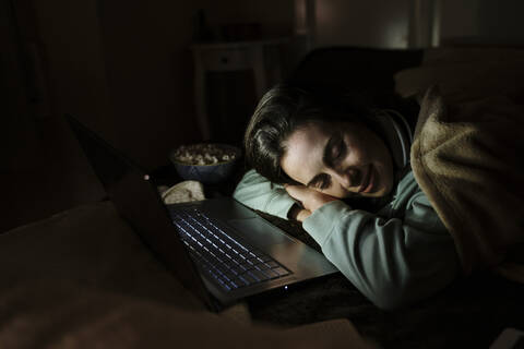 Frau mit Laptop entspannt beim Schlafen zu Hause, lizenzfreies Stockfoto