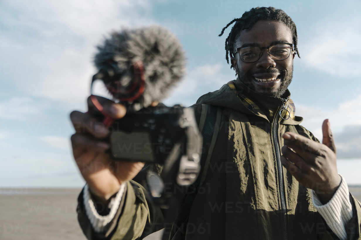 Picture of a r influencer smiling with a camera doing a