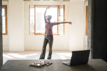 Frau mit Virtual-Reality-Simulator tanzt zu Hause - MOEF03574