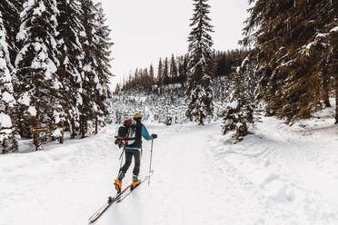 Älterer Mann beim Skifahren auf verschneitem Land im Urlaub - DAWF01773