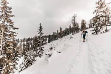 Senior man skiing on snow covered land during vacation - DAWF01776