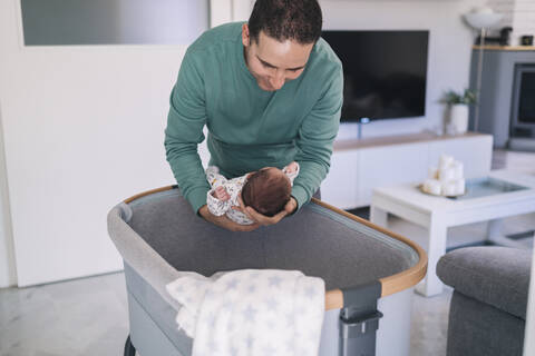 Caring father keeping son in crib at home stock photo