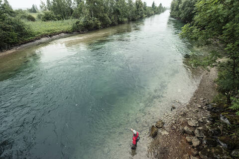 Expertise beim Fliegenfischen im Fluss stehend an der Loisach am Kochelsee, Bayern, Deutschland, lizenzfreies Stockfoto