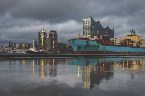 Germany, Hamburg, Anleger theatre, Elbe Philharmonic Hall and container ship reflecting in water stock photo