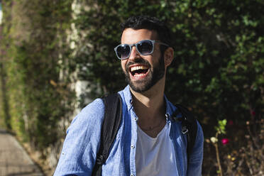 Gut gelaunter männlicher Geschäftsmann mit Sonnenbrille im Park - PNAF00750