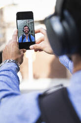 Geschäftsmann nimmt Selfie durch Smartphone - PNAF00755