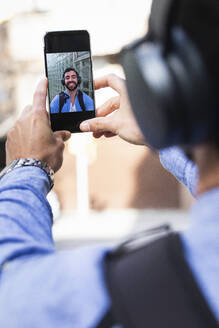 Businessman taking selfie through smart phone - PNAF00755