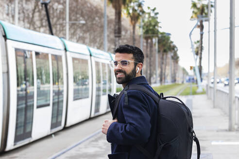 Smiling businessman waiting for train at station - PNAF00759