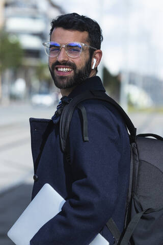 Smiling male entrepreneur in eyeglasses with digital tablet stock photo