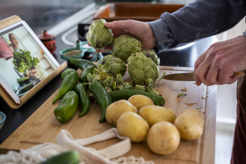 Senior man cutting vegetables for meal stock photo