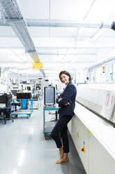 Female entrepreneur with arms crossed in factory - JOSEF03689