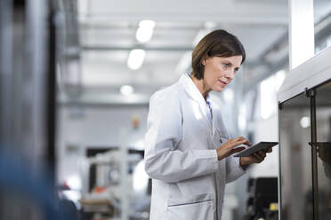 Ältere Technikerin mit digitalem Tablet im Labor - JOSEF03727