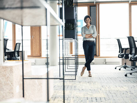 Mature female professional with arms crossed standing in office - JOSEF03752