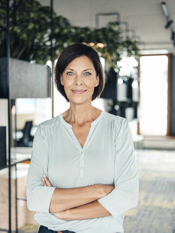 Female entrepreneur with arms crossed in office stock photo