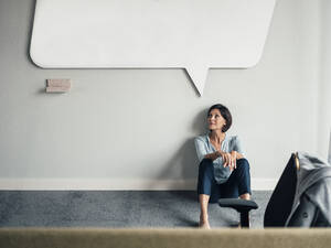 Nachdenkliche Geschäftsfrau schaut auf, während sie im Büro auf dem Boden sitzt - JOSEF03761